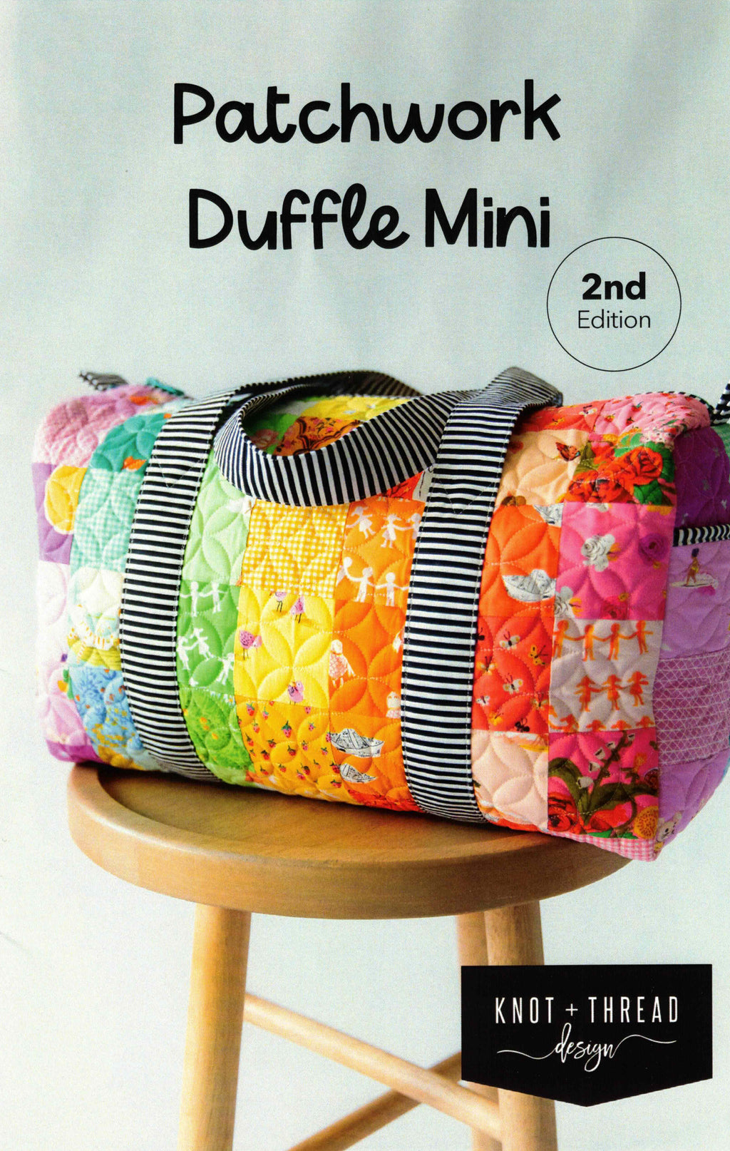 Patchwork duffle bag on a wooden stool with 'Knot + Thread Design' branding.