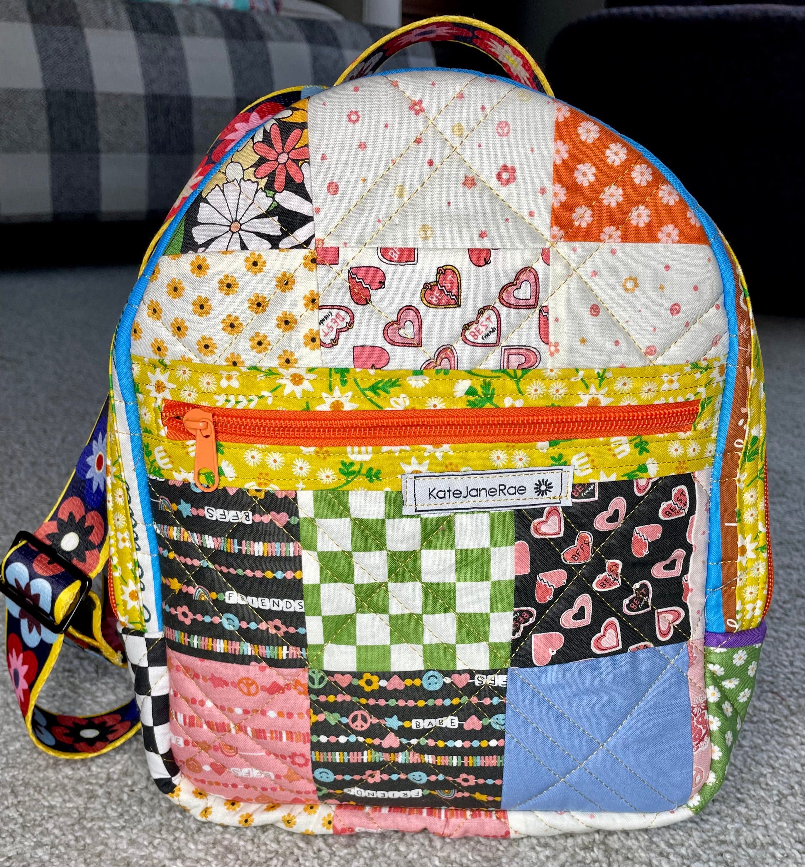 Colorful patchwork backpack with a visible brand label on a gray surface.