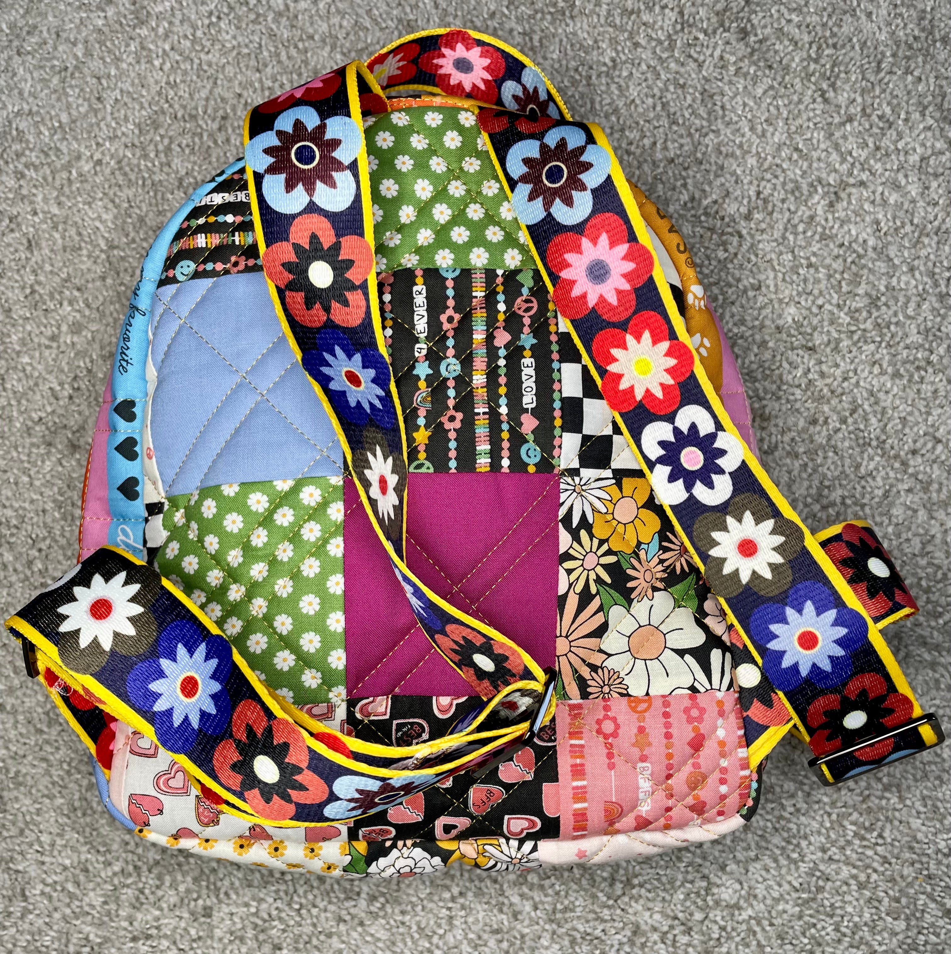 Colorful patchwork bag with floral patterns on a gray surface