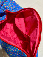 Blue floral-patterned bag with a red interior on a light background