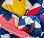 Colorful quilt with star pattern in blue, red, yellow, and white.