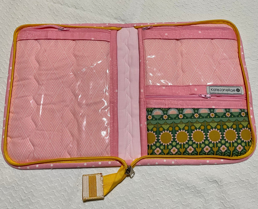 Pink travel pouch with floral pattern on a textured white background