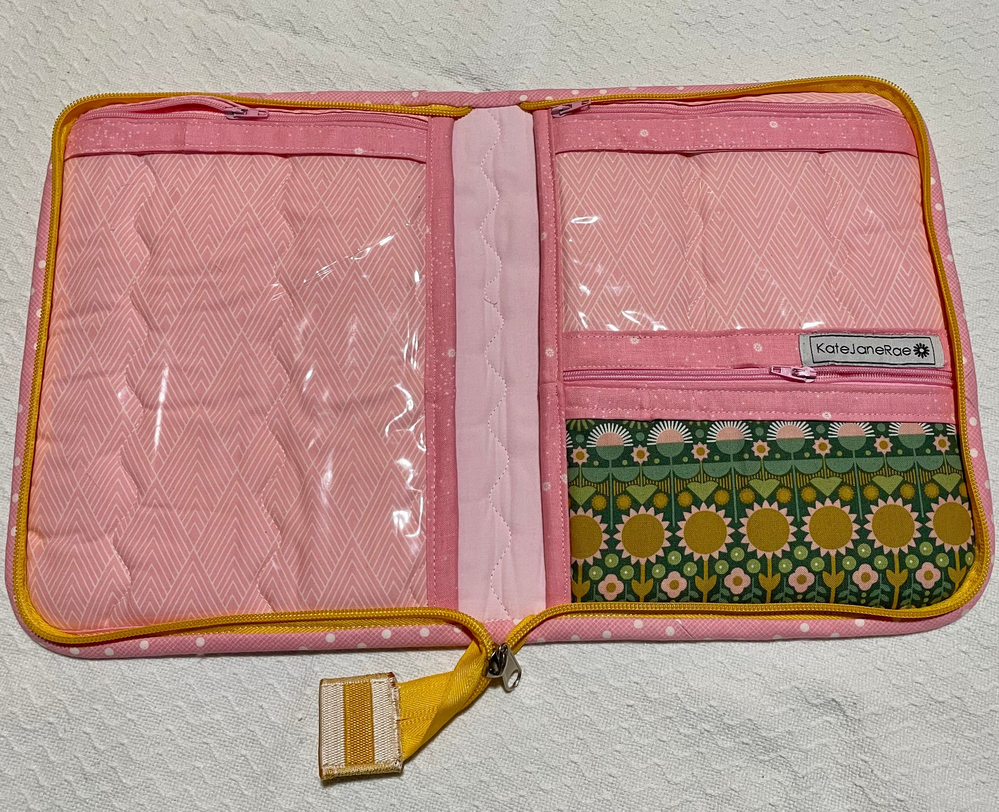 Pink travel pouch with floral pattern on a textured white background