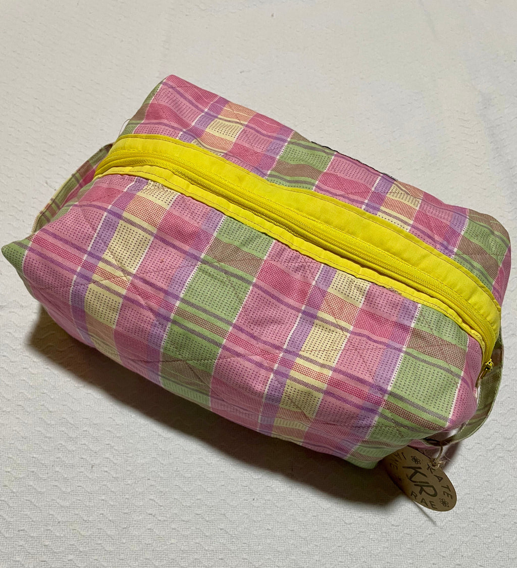 Plaid pouch with yellow zipper on a light gray background