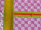Pink checkered pouch with yellow zipper on a gray surface
