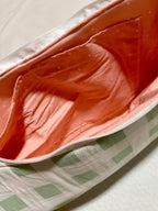Close-up of a pink cushion with a checkered blanket underneath