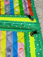 Green polka dot wallet with colorful labels on a gray surface