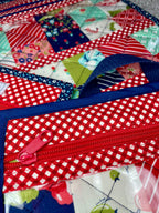 Close-up of a colorful quilt with a red zipper