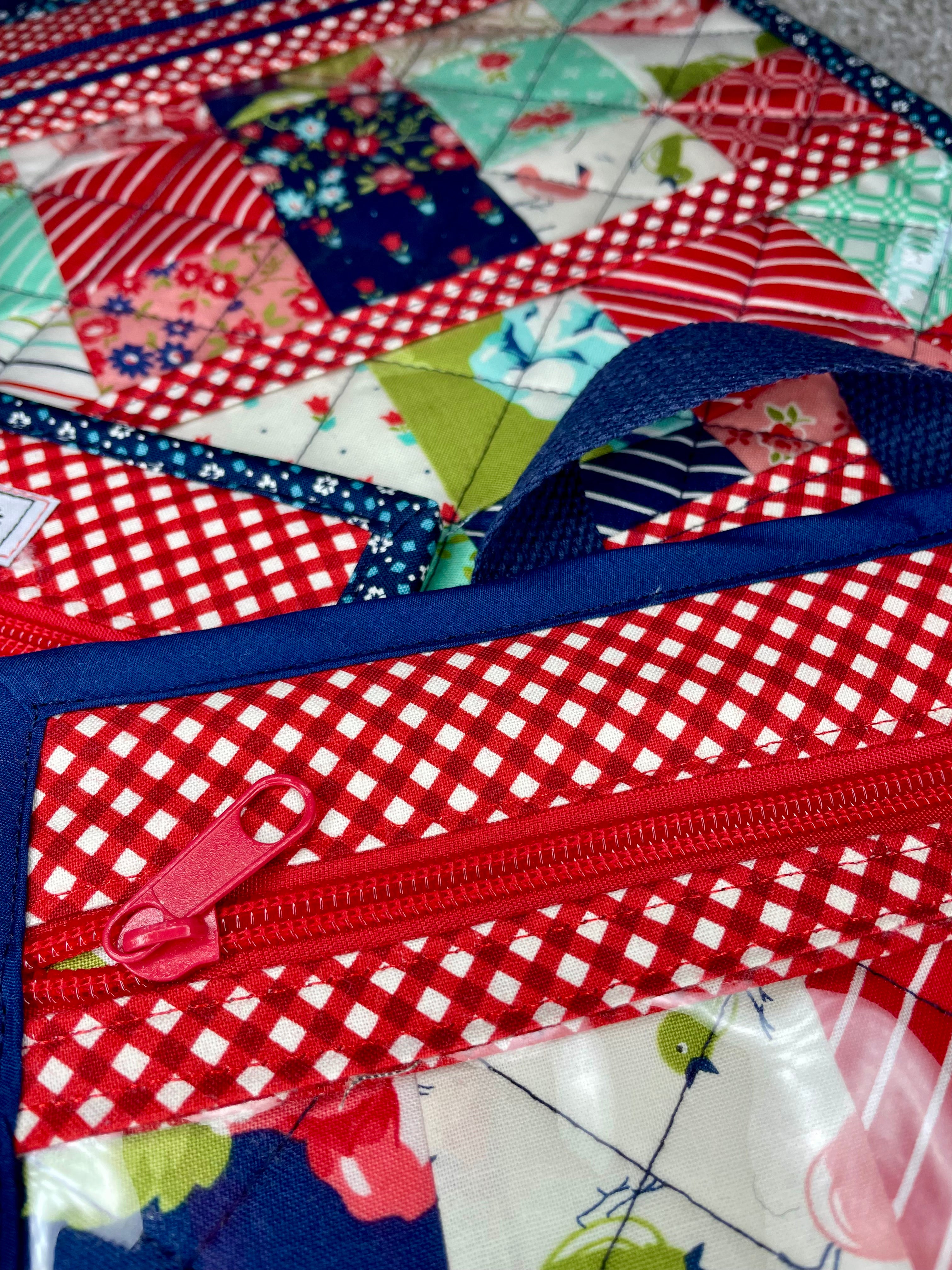 Close-up of a colorful quilt with a red zipper