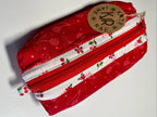 Red and white patterned fabric pouch with a visible brand label on a white background