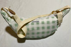 Green checkered bag with beige strap on a light gray background