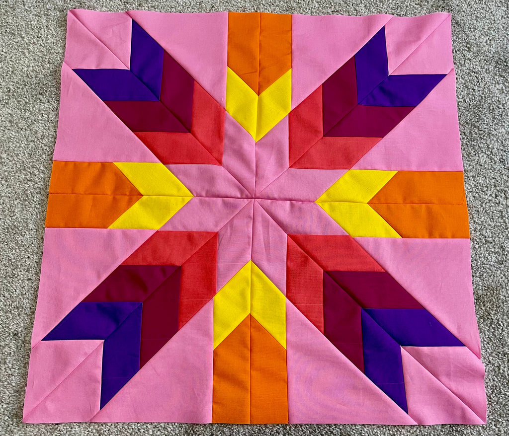 Colorful geometric quilt block on a pink background
