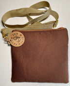 Brown bag with a beige strap and visible brand tag on a white background