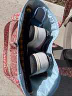 Tote bag with New Balance shoes on a concrete surface