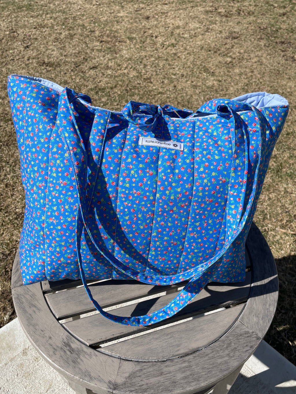 Blue patterned bag on a wooden chair outdoors