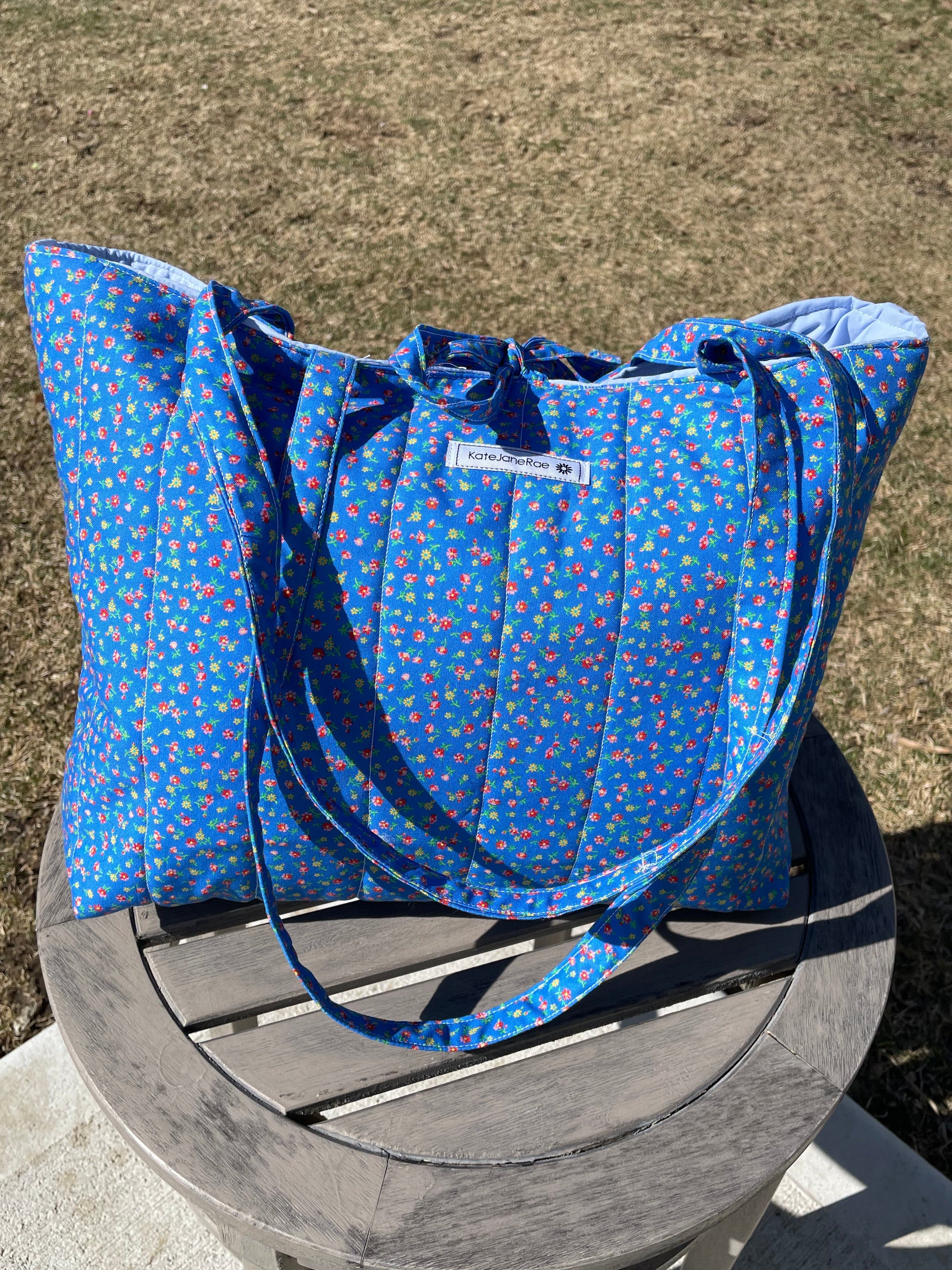 Blue patterned bag on a wooden chair outdoors