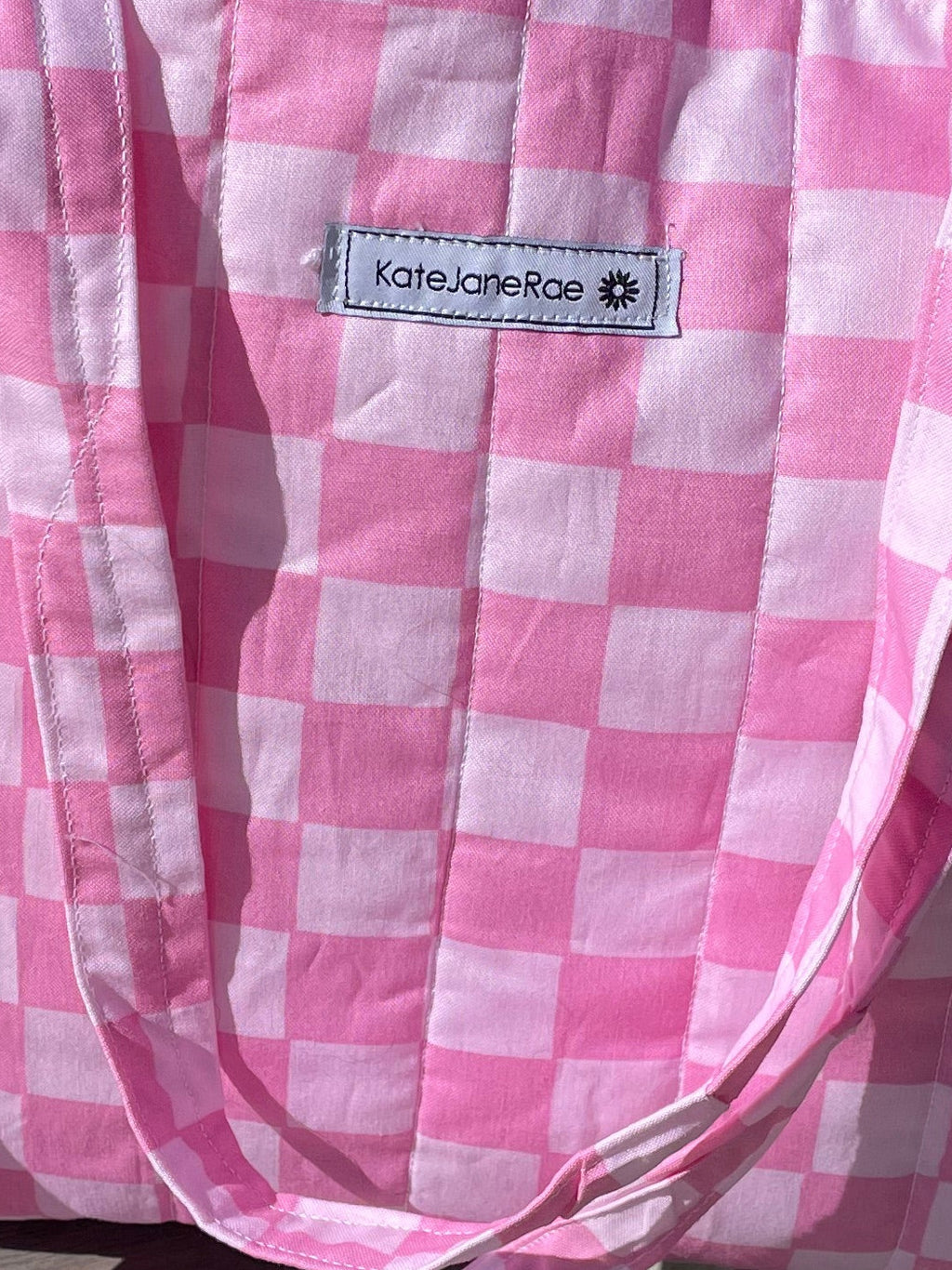 Pink checkered bag on a concrete surface