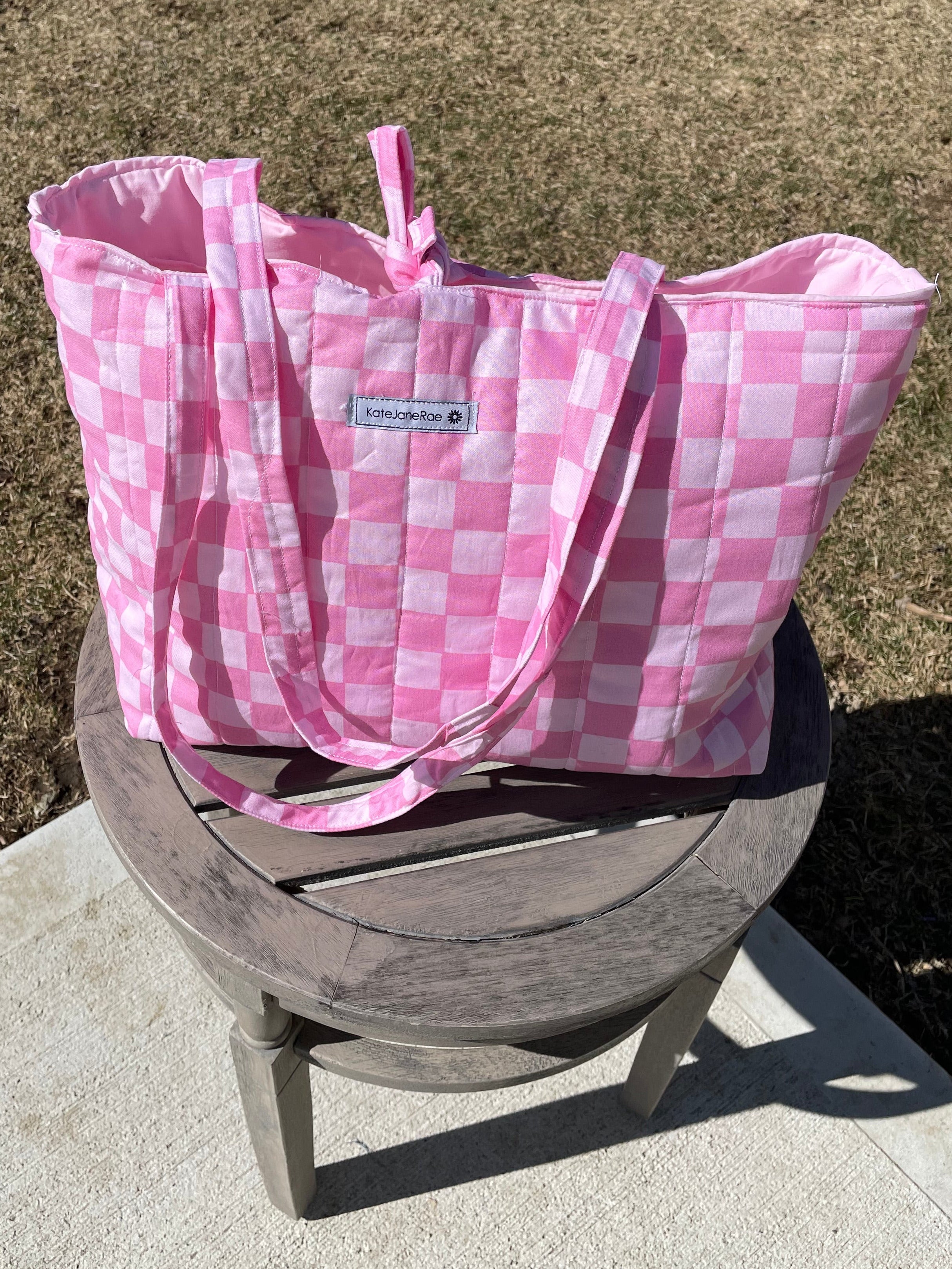 Pink checkered bag on a concrete surface