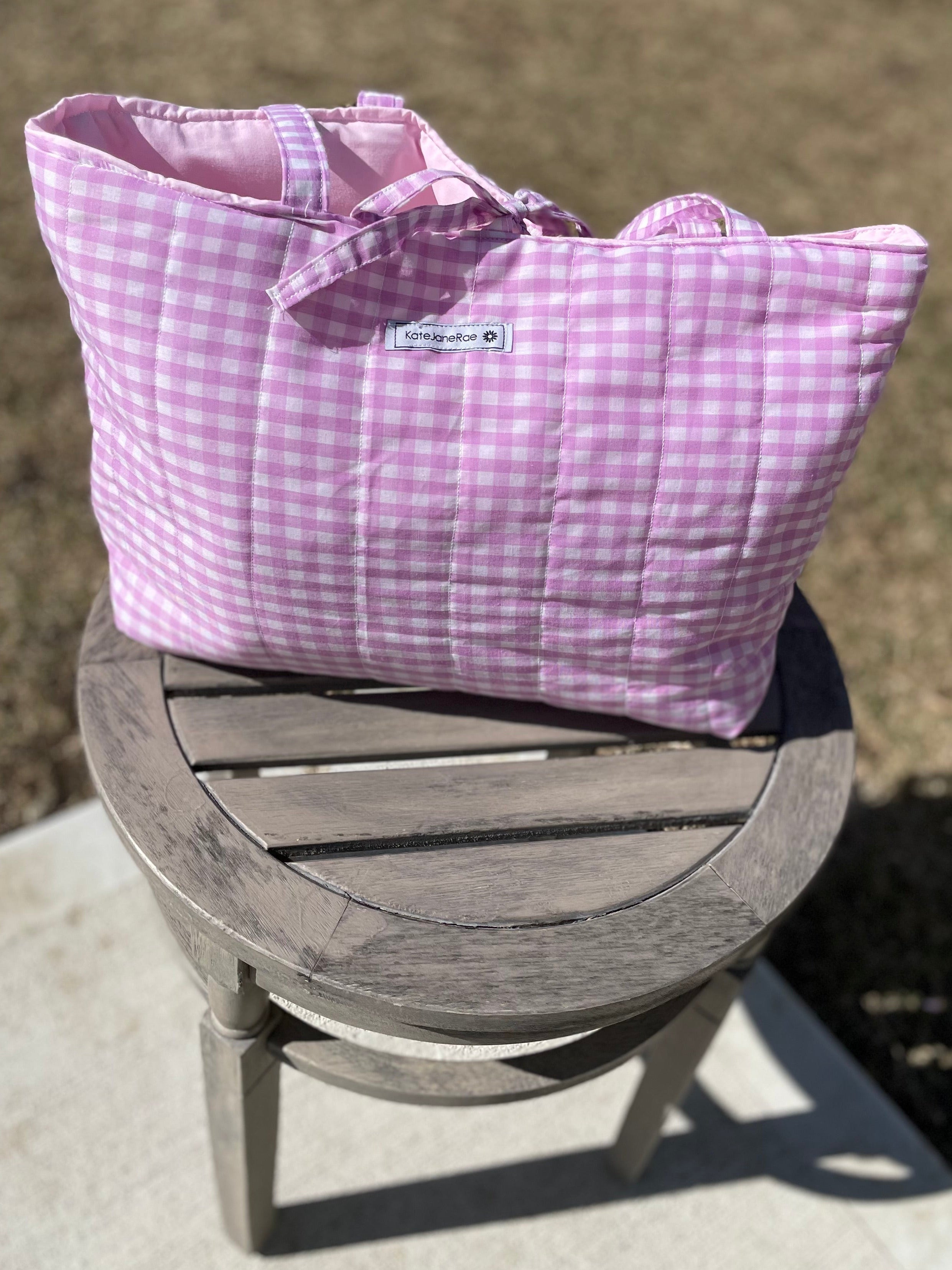 Purple checkered bag on a small wooden stool outdoors