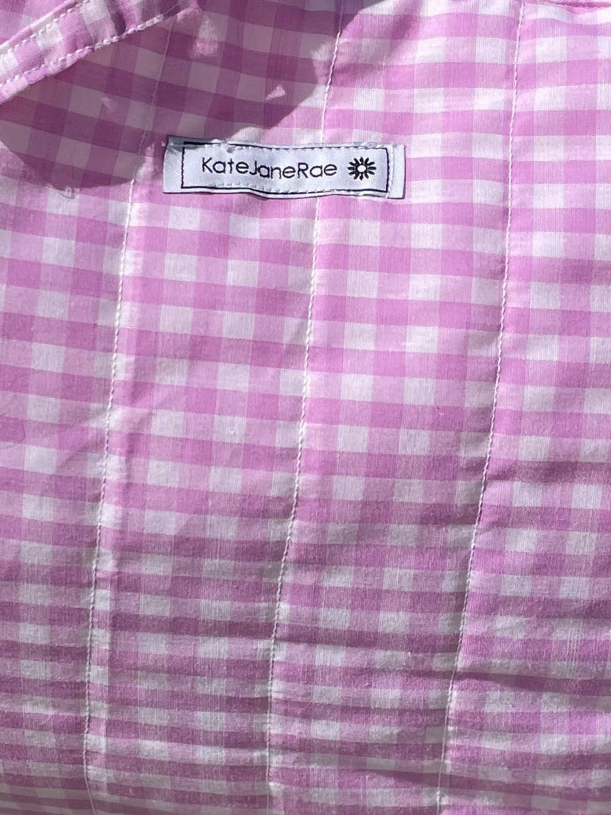 Pink checkered bag on a wooden stool outdoors