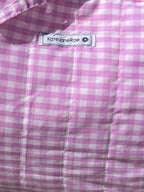 Pink checkered bag on a wooden stool outdoors