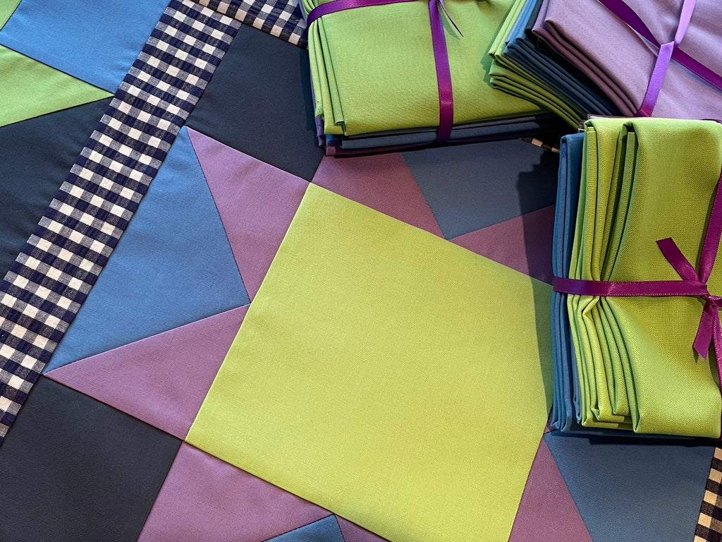 Colorful fabric squares and bundles on a wooden surface