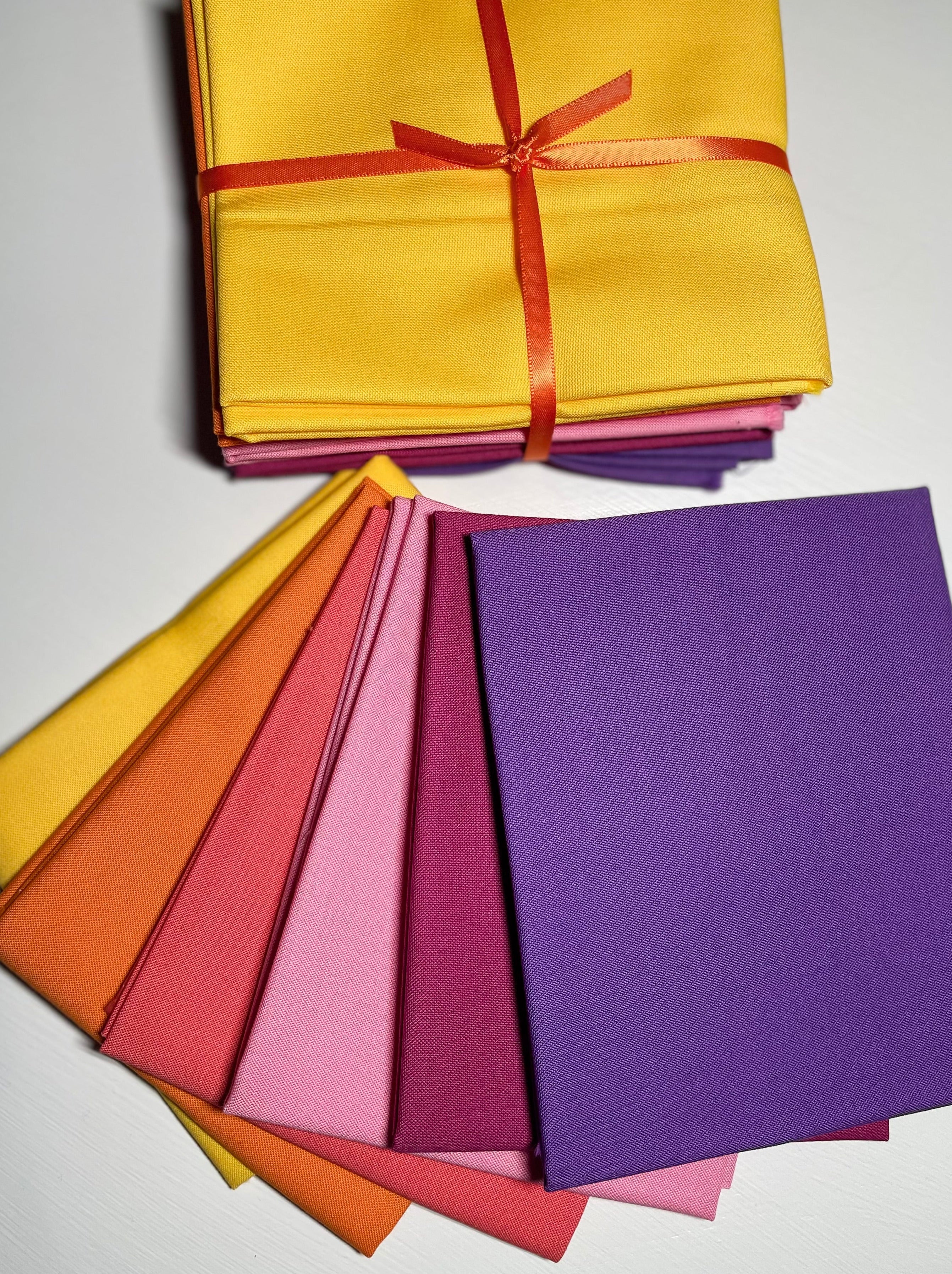 Colorful paper sheets with a yellow sheet tied with a red ribbon on a white background