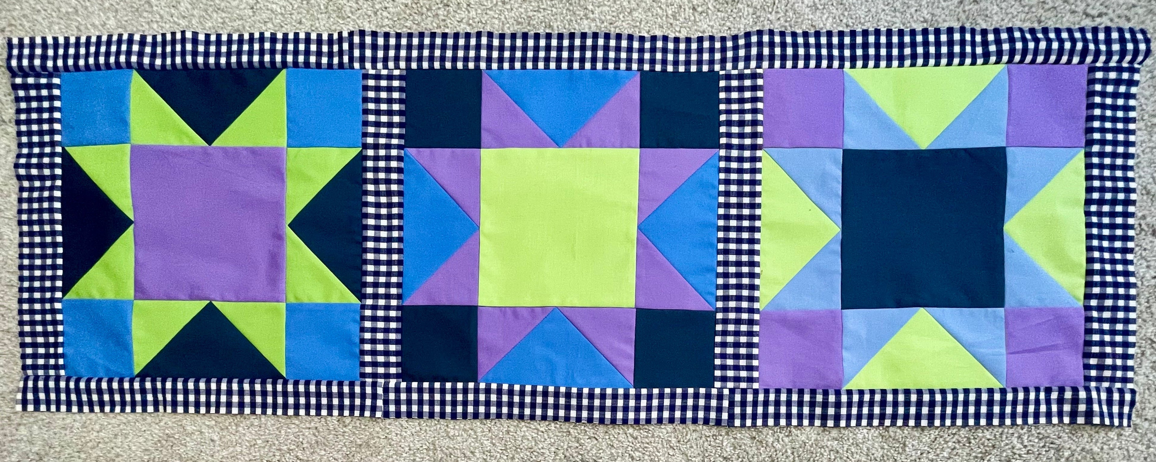 Quilted table runner with geometric pattern on a checkered background