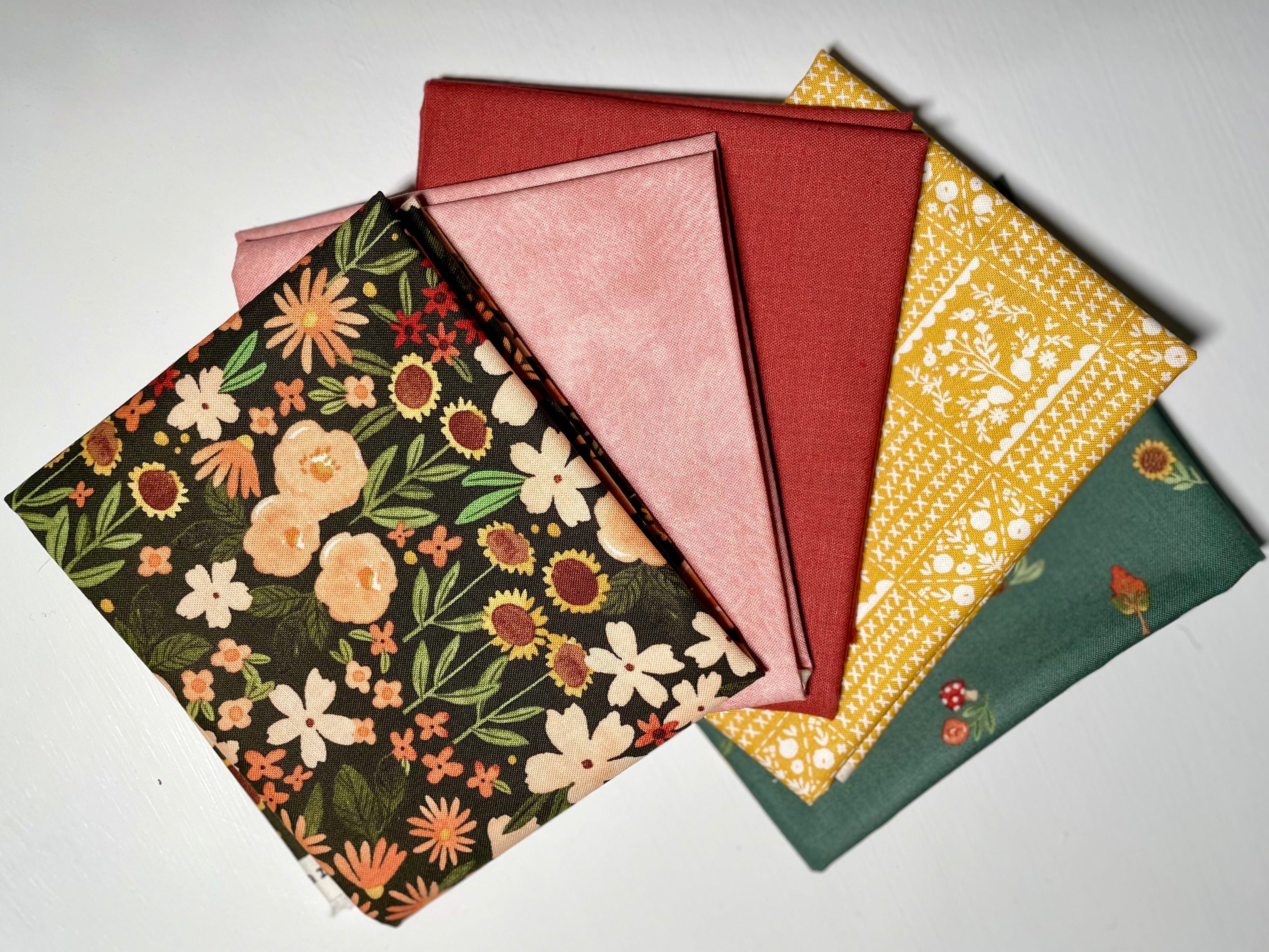 Colorful fall fabric bundle on white table