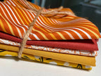 Stack of colorful fabric swatches tied together on a white surface