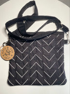 Black bag with white zigzag pattern and a strap on a white background