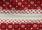 Red and white patterned zippered pouch with a visible brand tag on a white background