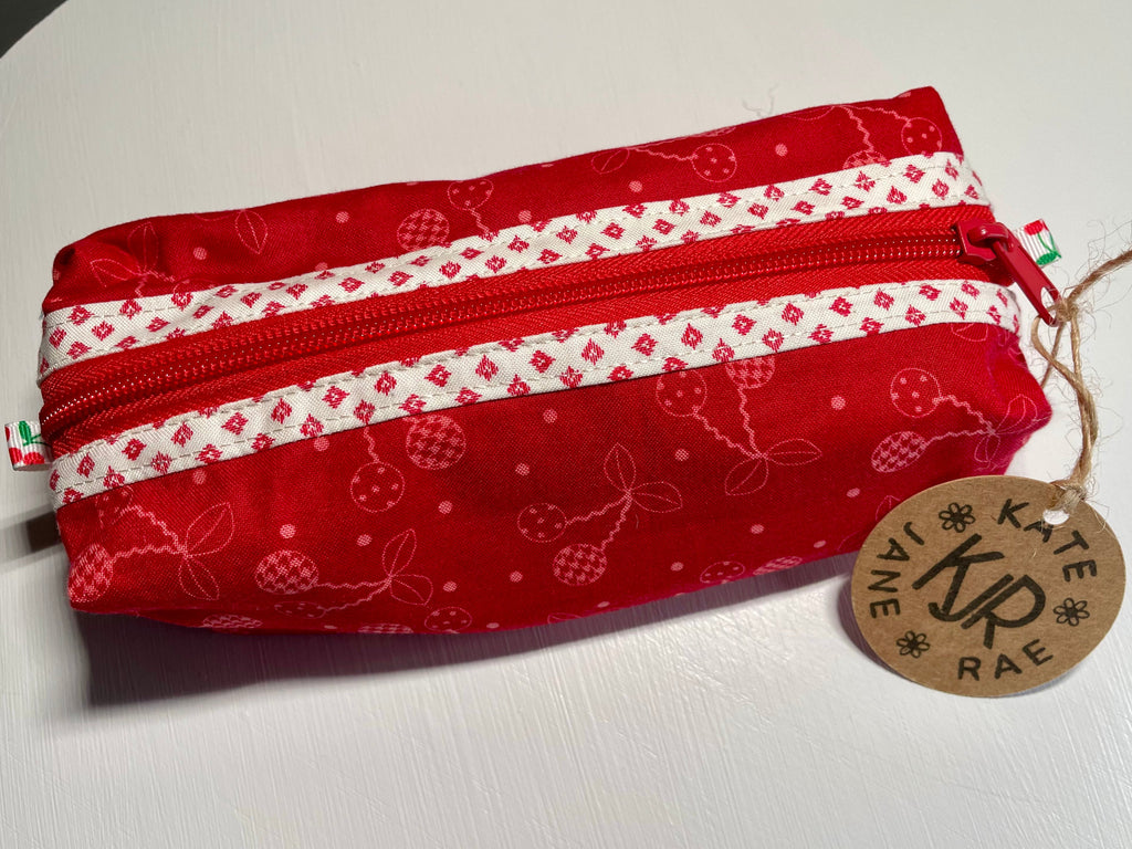 Red and white patterned pouch with a visible brand tag on a light background