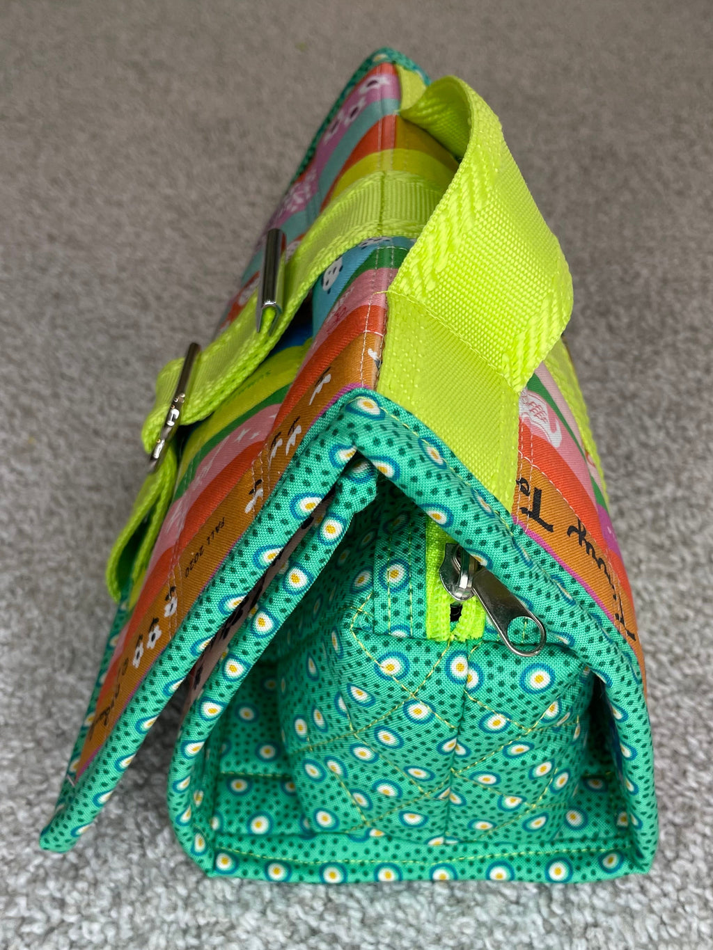 Colorful fabric bag with a green interior on a gray surface