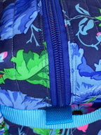 Floral-patterned pencil case with a blue zipper on a beige carpet