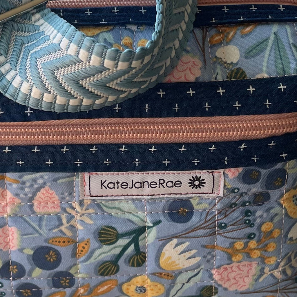Floral-patterned pouch on a sewing machine with a wooden surface