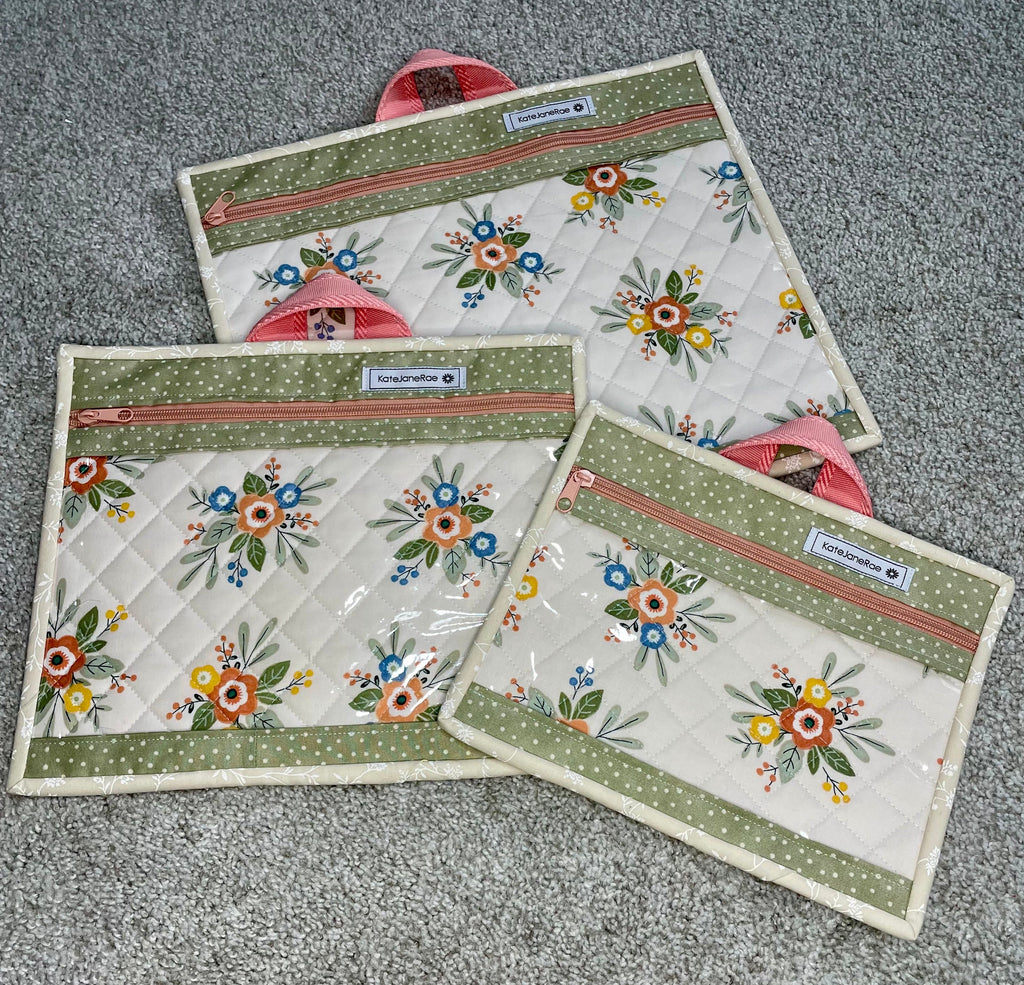 Set of three floral-patterned pouches on a gray surface