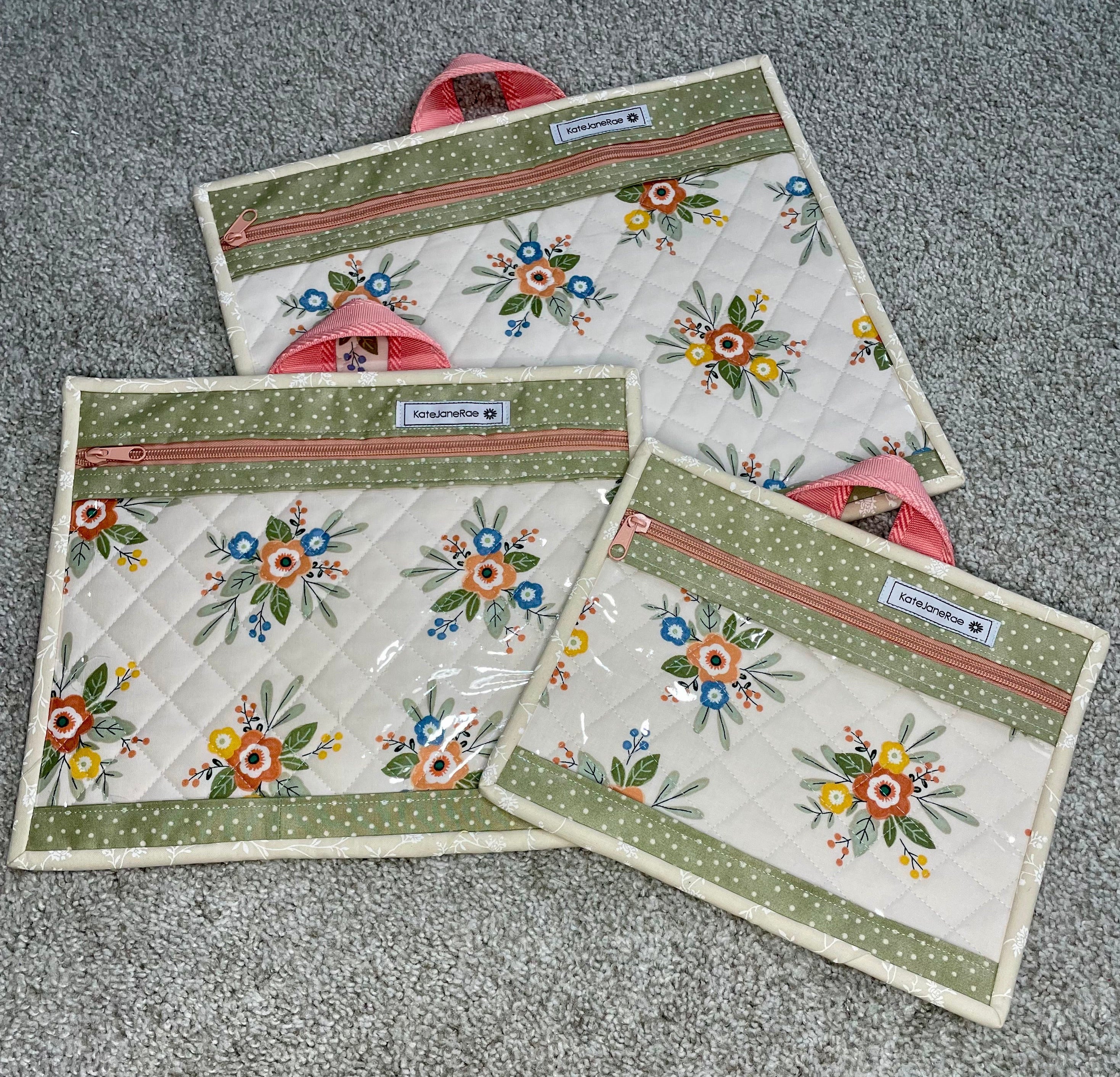 Set of three floral-patterned pouches on a gray surface