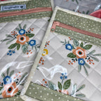 Floral-patterned pouches with zippers on a quilted surface