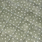 Set of floral quilted placemats with pink ribbons on a gray surface