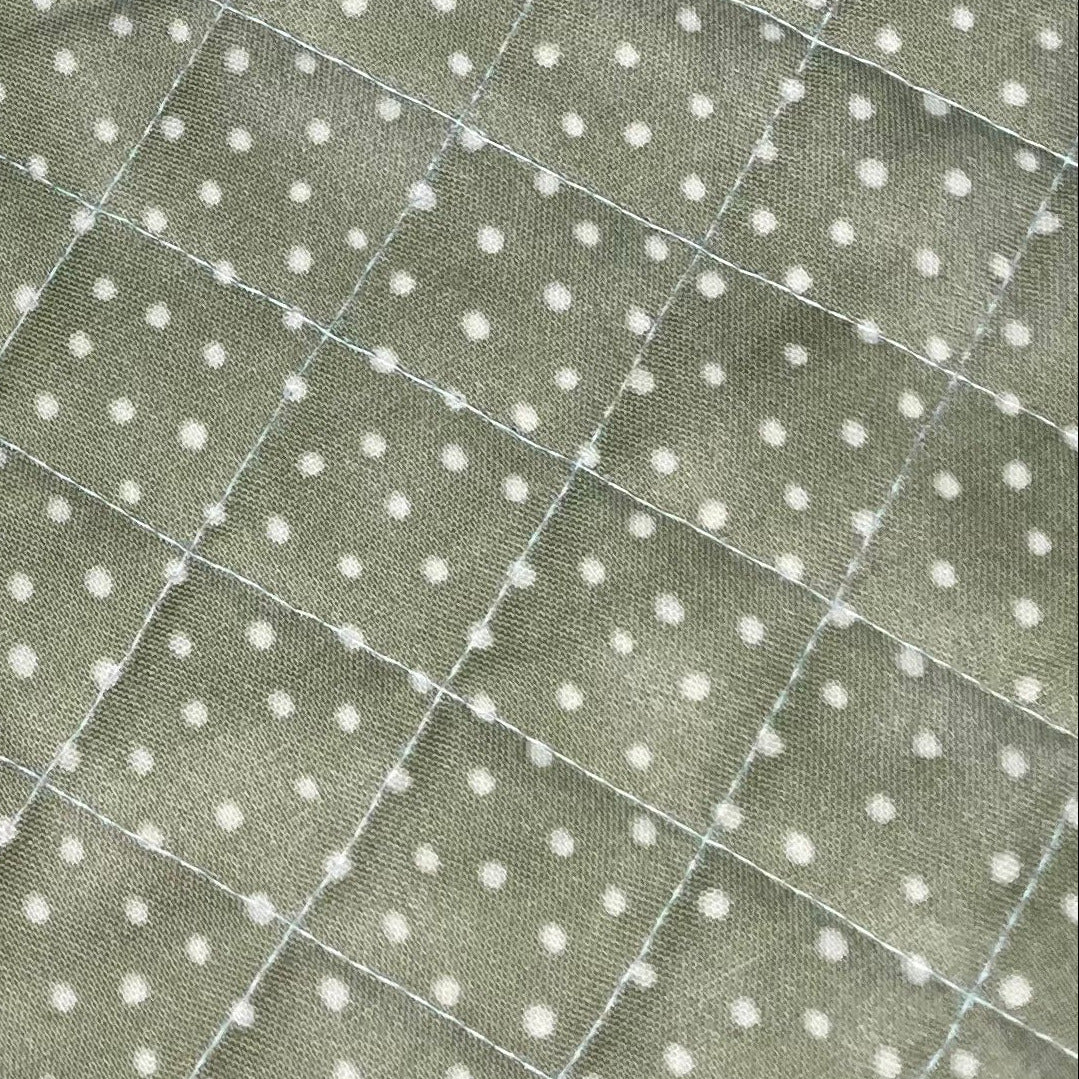 Set of floral quilted placemats with pink ribbons on a gray surface