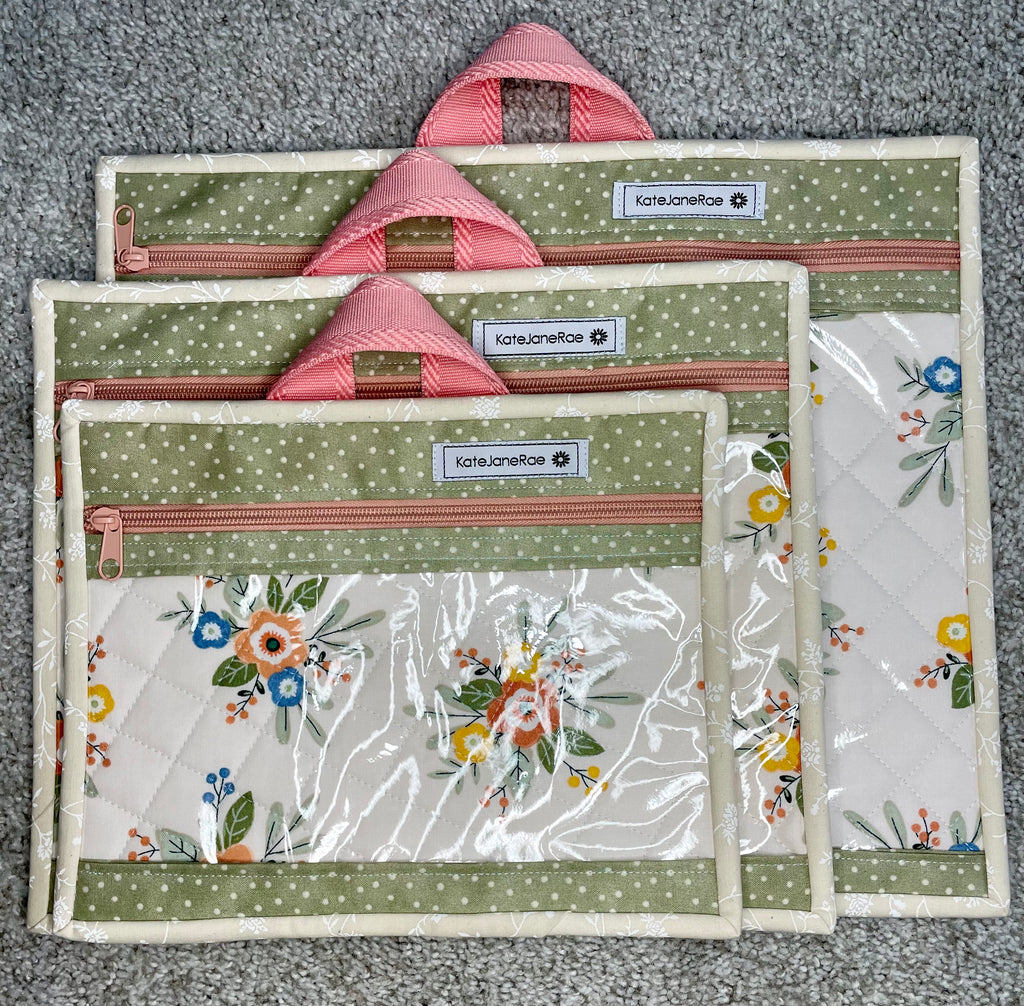 Set of four fabric pouches with floral and polka dot patterns on a gray surface.