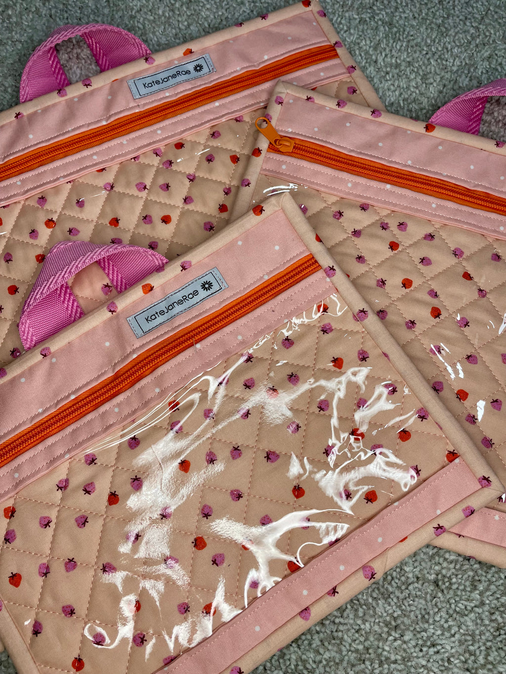 Set of three quilted pouches with decorative patterns on a textured surface