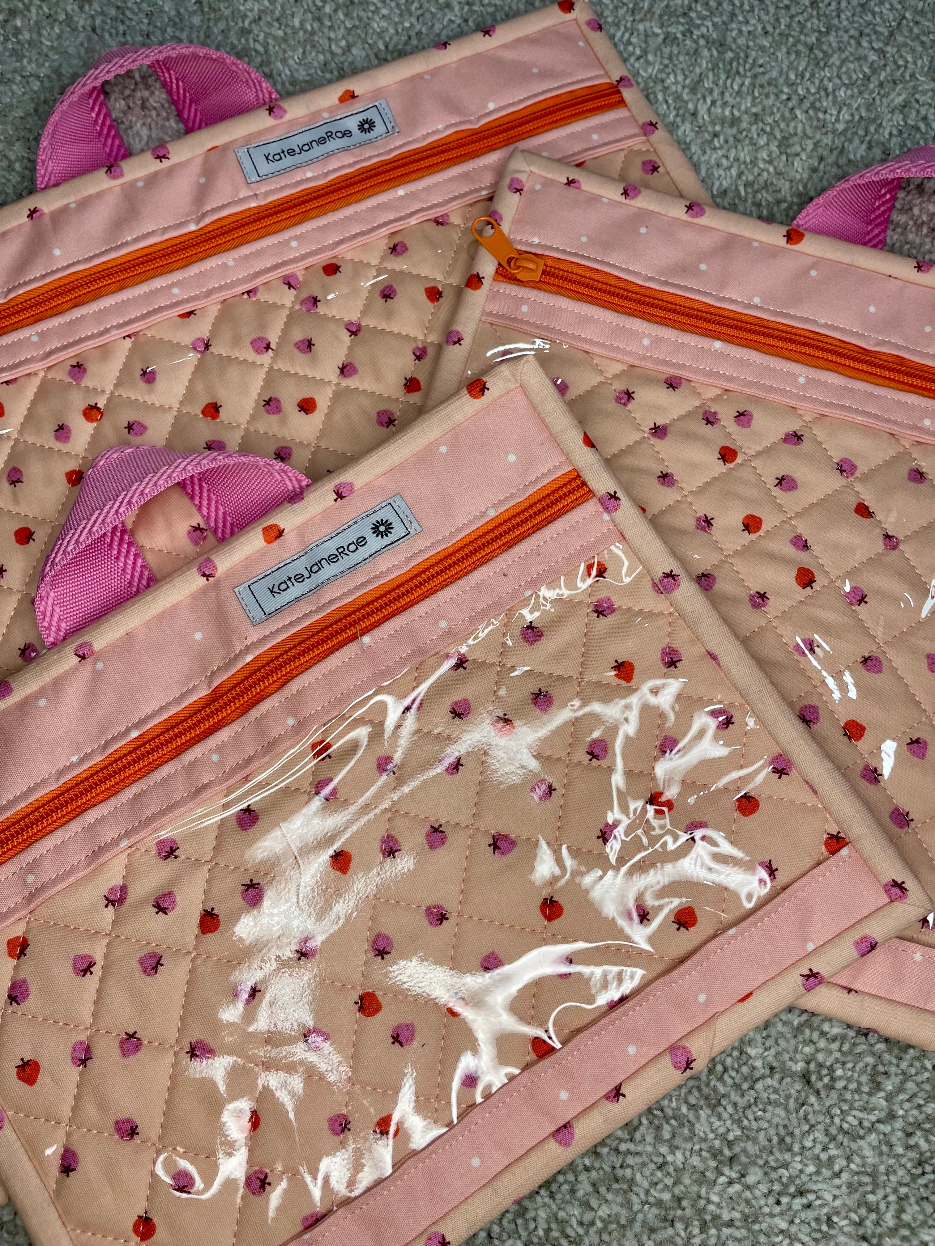 Set of three quilted pouches with decorative patterns on a textured surface