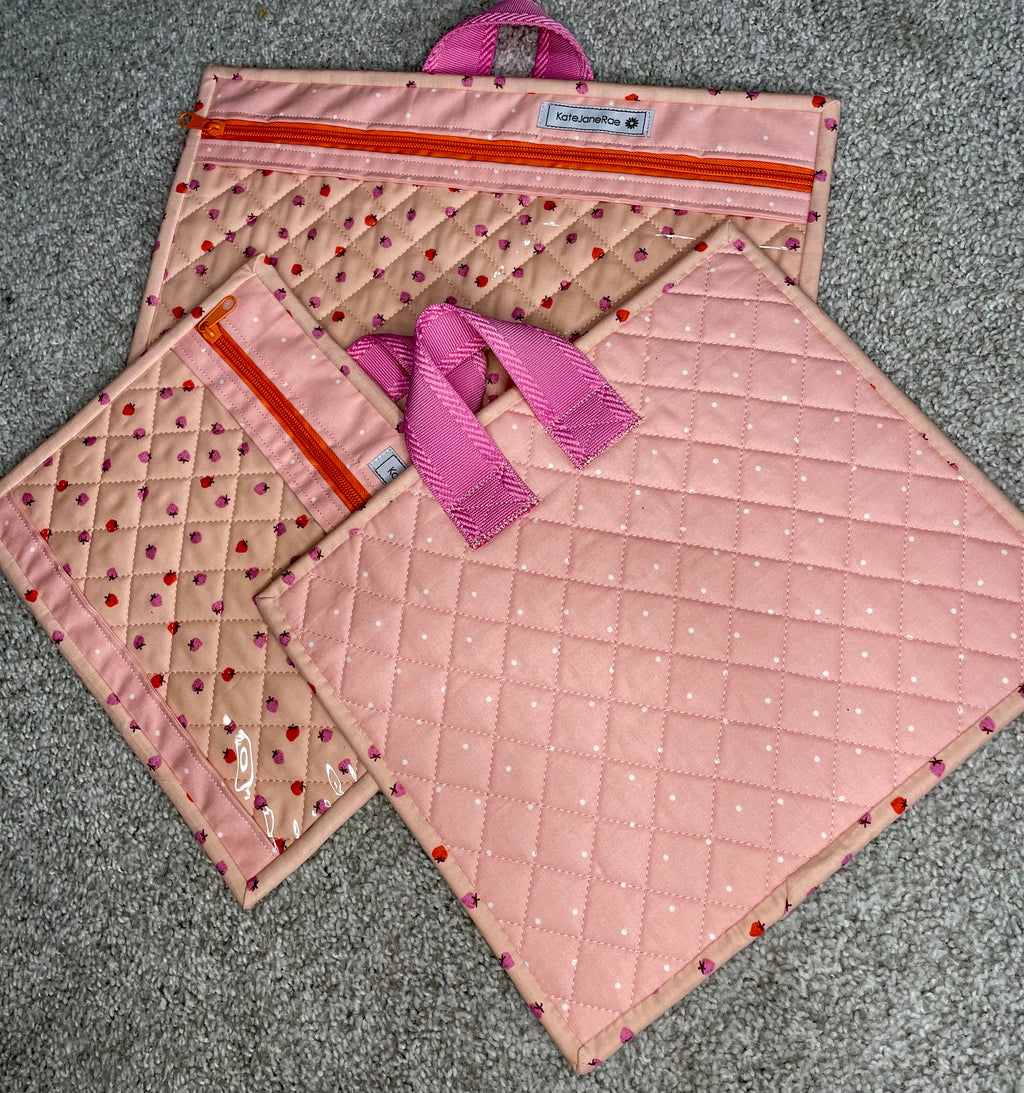 Set of pink quilted bags with polka dot pattern on a gray surface