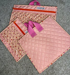 Set of pink quilted bags with polka dot pattern on a gray surface