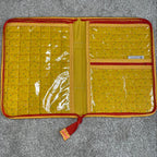 Yellow quilted wallet with red accents on a gray surface