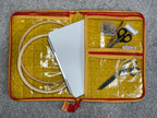 Embroidery kit with scissors, thread, and hoop on a gray surface