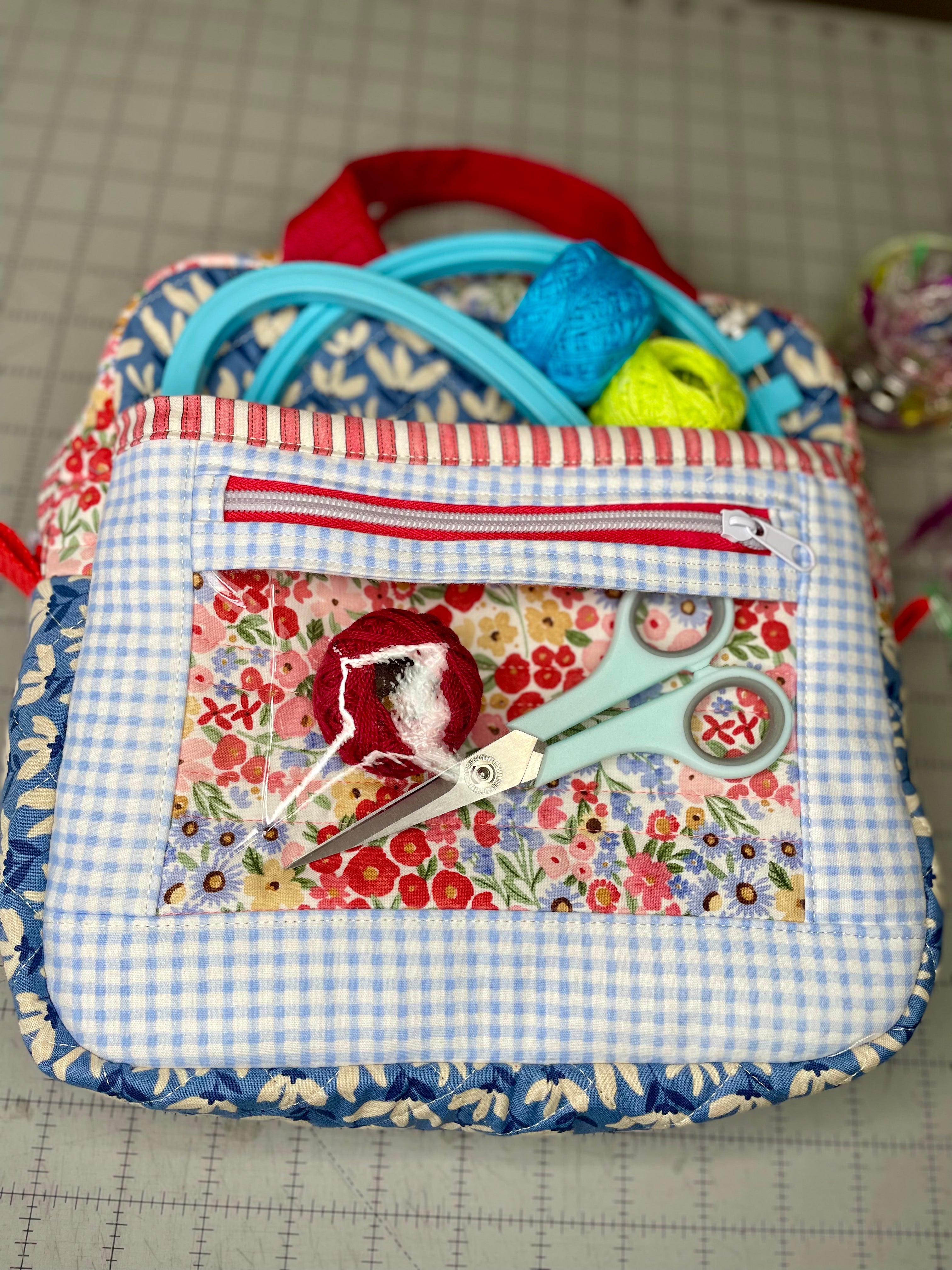 Fabric pouch with scissors and thread on a cutting mat
