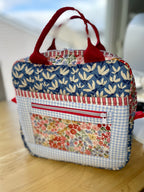 Fabric bag with floral and checkered patterns on a wooden surface